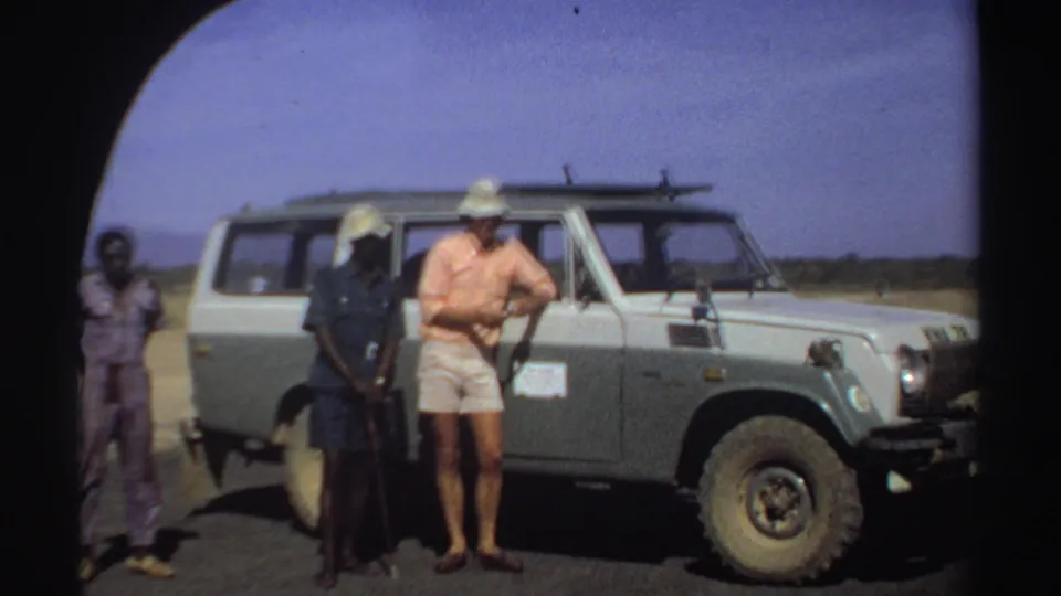 The final frame shows the three men grouped beside the safari-style vehicle in a sunny Sudan landscape from 1969.