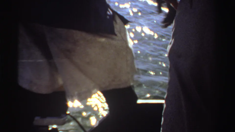 A 1969 Sudan frame shows a person near the edge of a pier or boat, with a fishing line visible over the water.