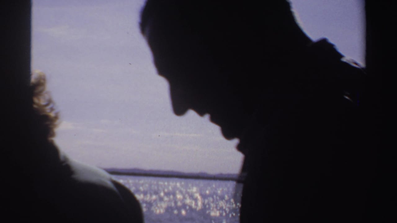 Dark profile of an adult man leaning forward with sunlit water behind him.
