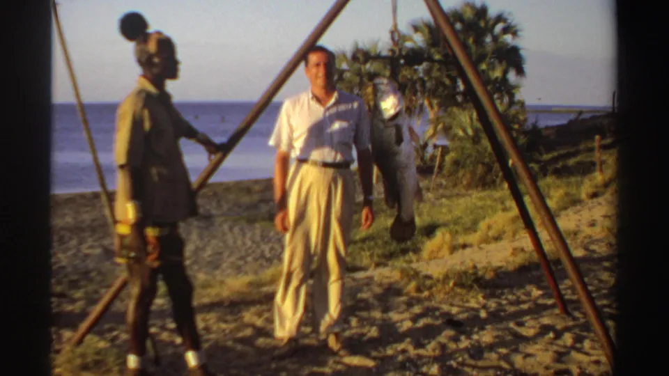 In the final 1969 Sudan frame, a man in light clothing stands near a suspended fish while another adult stands beside the frame.