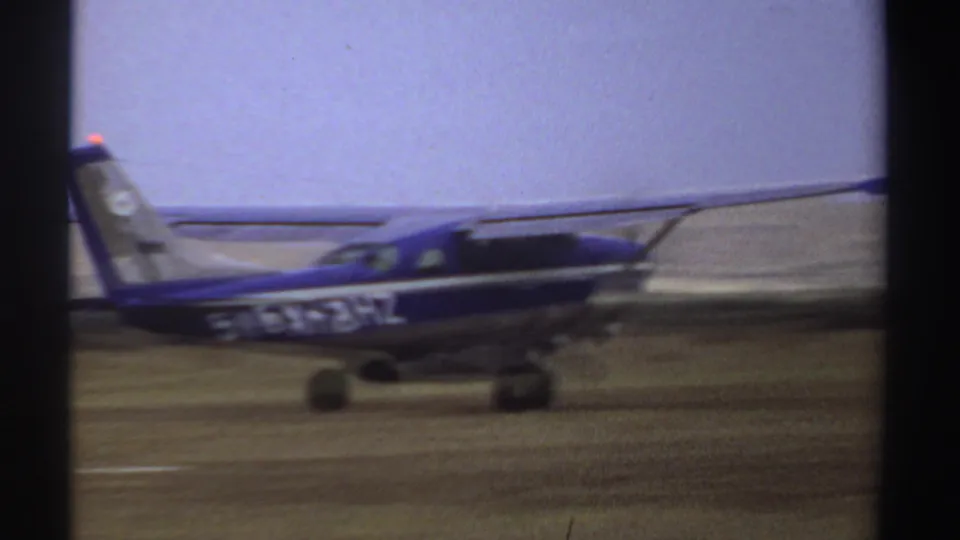 A closer side view shows the blue and white aircraft body, tail, landing gear, and partial registration markings.