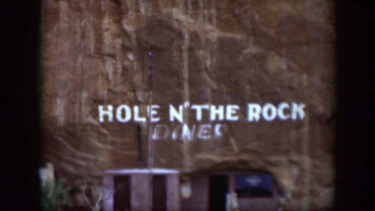 1951 Utah 8mm frame showing the Hole N' The Rock Diner sign centered on a textured sandstone wall above the entrance.