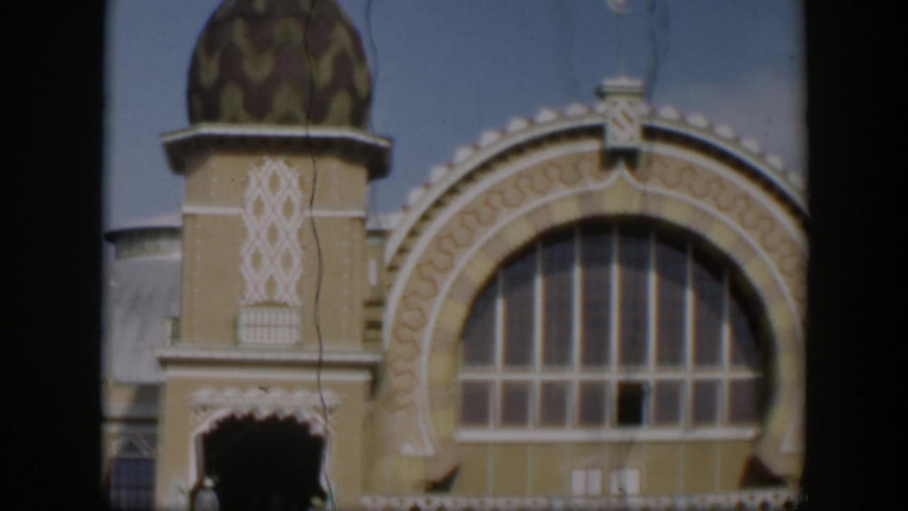 1951 Utah 8mm frame with a domed tower, decorative geometric trim, and a large arched window on a religious building exterior.
