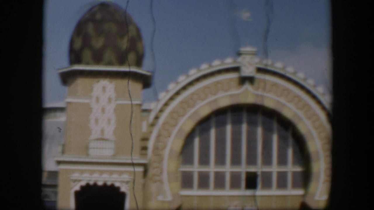 1951 Utah 8mm frame showing a domed tower, patterned wall decoration, scalloped entrance, and large arched window on the facade.