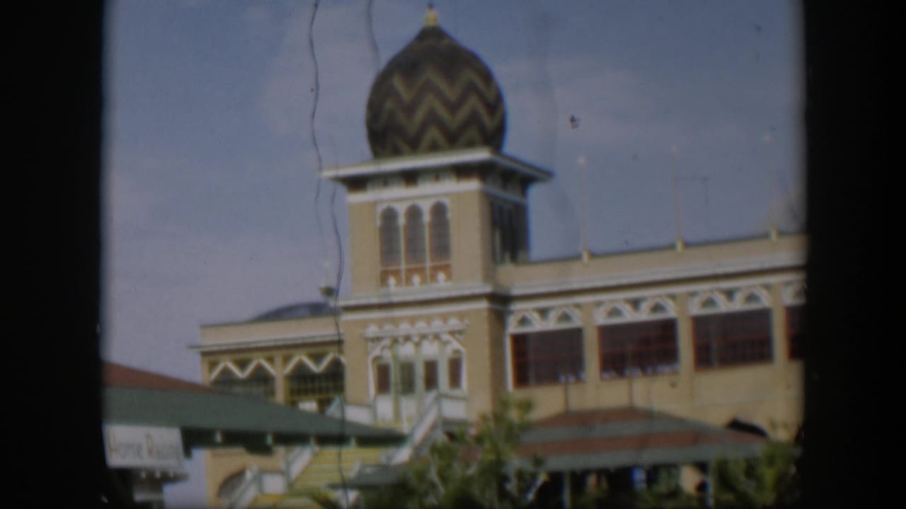 1951 Utah-labeled 8mm view holding on the building tower, with its chevron-patterned dome, arched windows, striped stairs, and soft film texture.