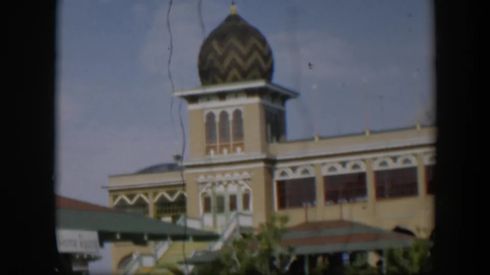 1951 Utah-labeled 8mm view holding on the building tower, with its chevron-patterned dome, arched windows, striped stairs, and soft film texture.