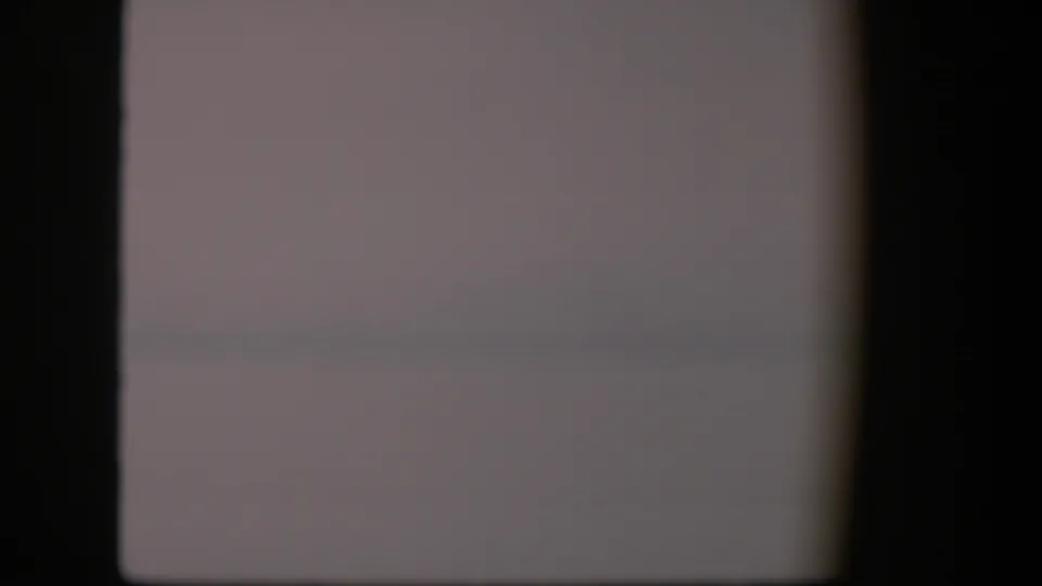 1951 Utah 8mm frame with a mostly clear pale microscope field, faint specks, and dark borders from the film scan.