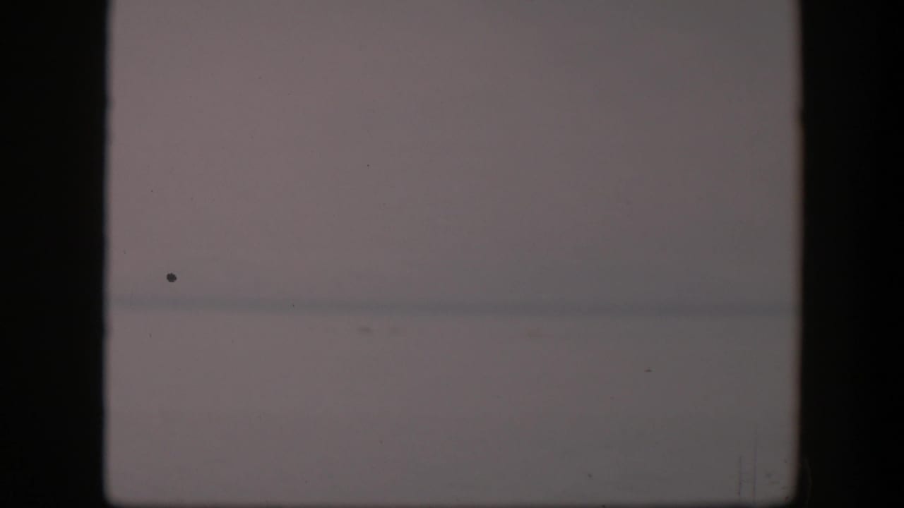 Washed-out horizon with dust specks and dark vertical gate edge.