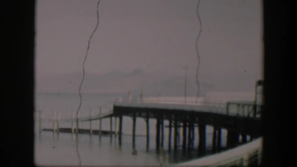 1951 Utah 8mm view of a pier over muted water, softened by fog and visible film wear.
