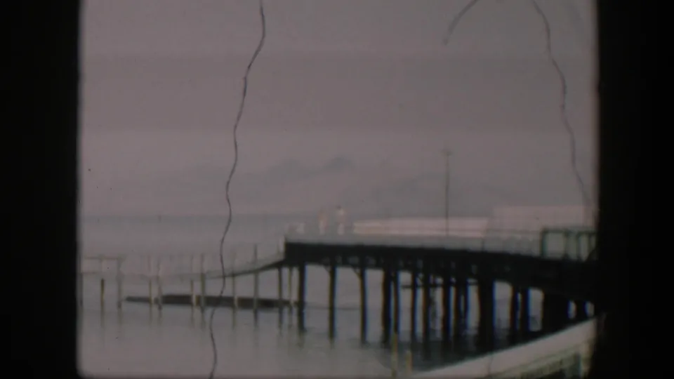 1951 Utah 8mm frame showing a foggy pier scene with indistinct people visible on the deck.