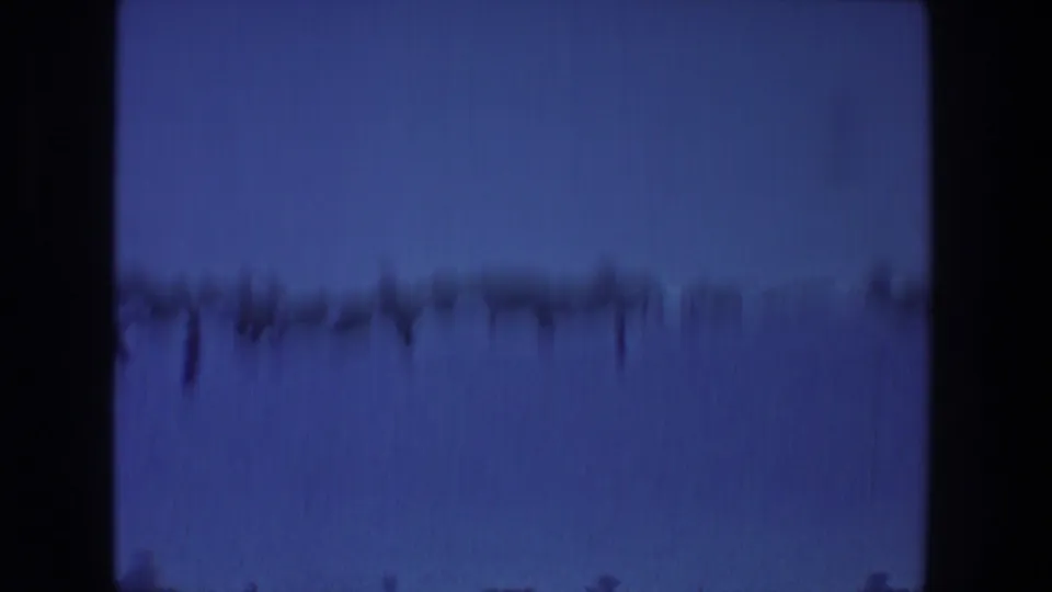 Blue-tinted final 8mm frame from the 1968 Toledo reel, showing a faint distant horizon beneath a dark gate edge.