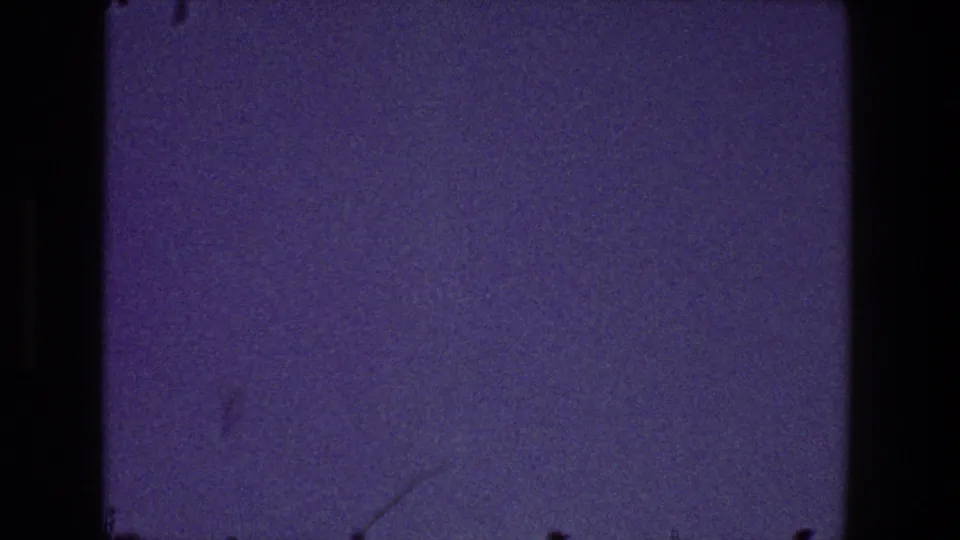 A mostly empty blue-purple sky fills the 1968 Toledo 8mm frame, with dark film borders, grain, and faint surface marks visible.