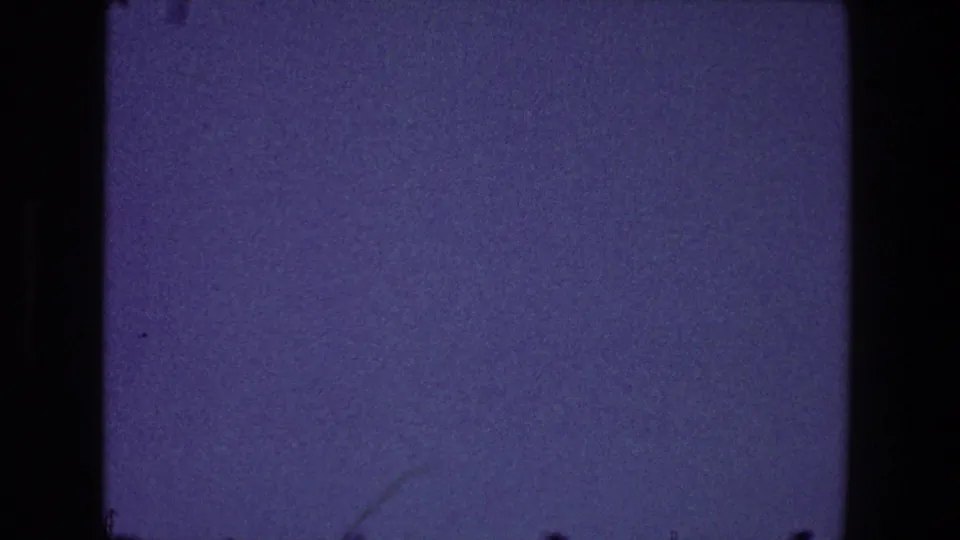 1968 Toledo home-movie frame showing a soft blue sky, faint lower tree branches, and rounded 8mm frame edges.
