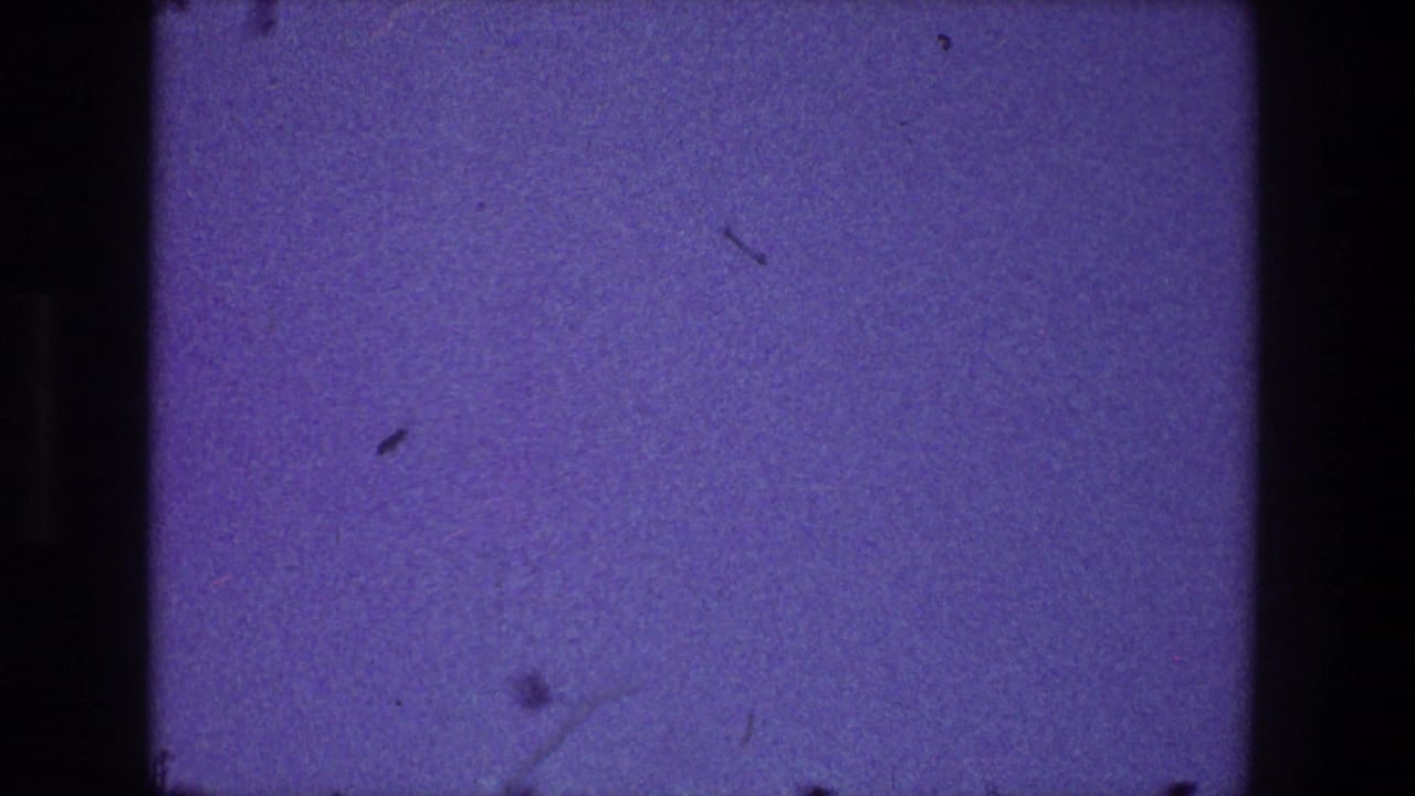 1968 Toledo 8mm frame showing a mostly empty purplish-blue field with visible dust, scratches, and dark rounded film edges.
