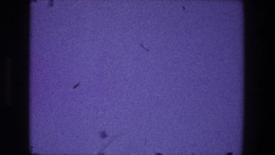 1968 Toledo 8mm frame showing a mostly empty purplish-blue field with visible dust, scratches, and dark rounded film edges.