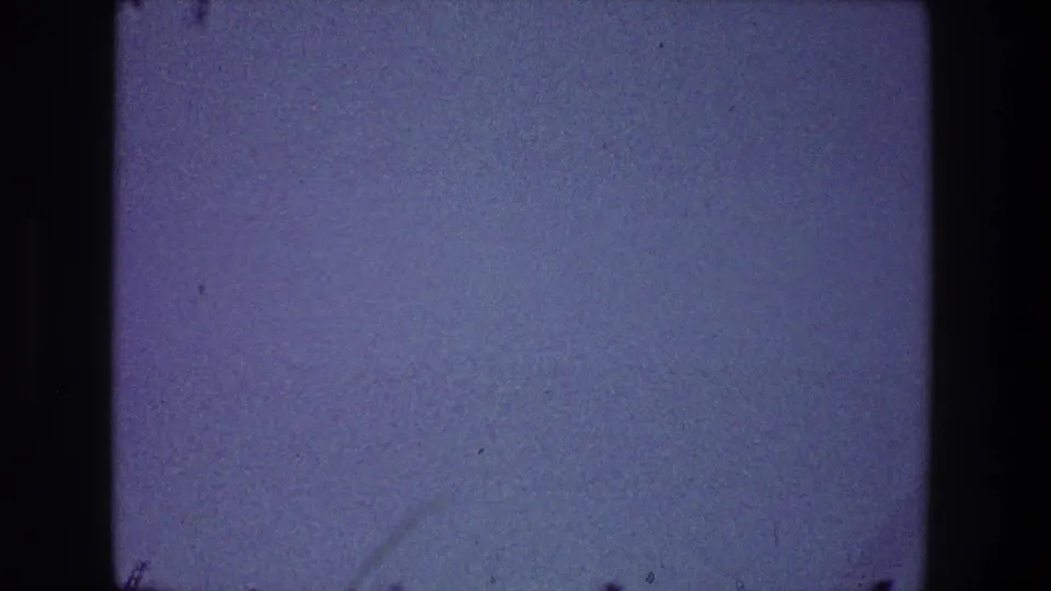 Open blue sky from the 1968 Toledo home-movie clip, with film dust, faint scratches, and no clearly visible bird in this frame.