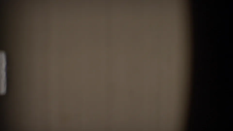 End frame from the 1968 Toledo 8mm clip, with a soft film surface, dark edge, and small pale moving mark.