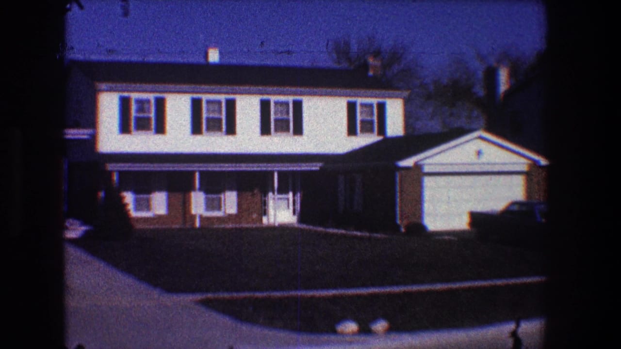 Two-story suburban house with shutters, garage, driveway, sidewalk, and lawn.