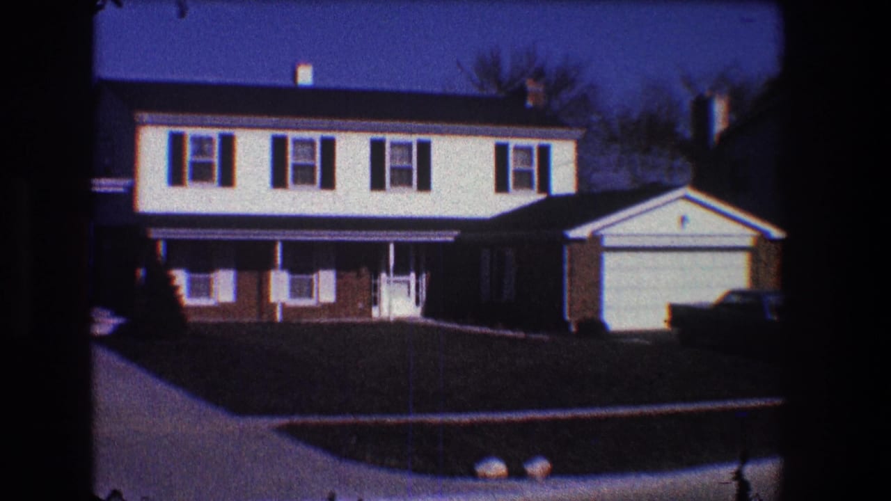 Brown-and-white split-level house with attached garage under a blue sky.