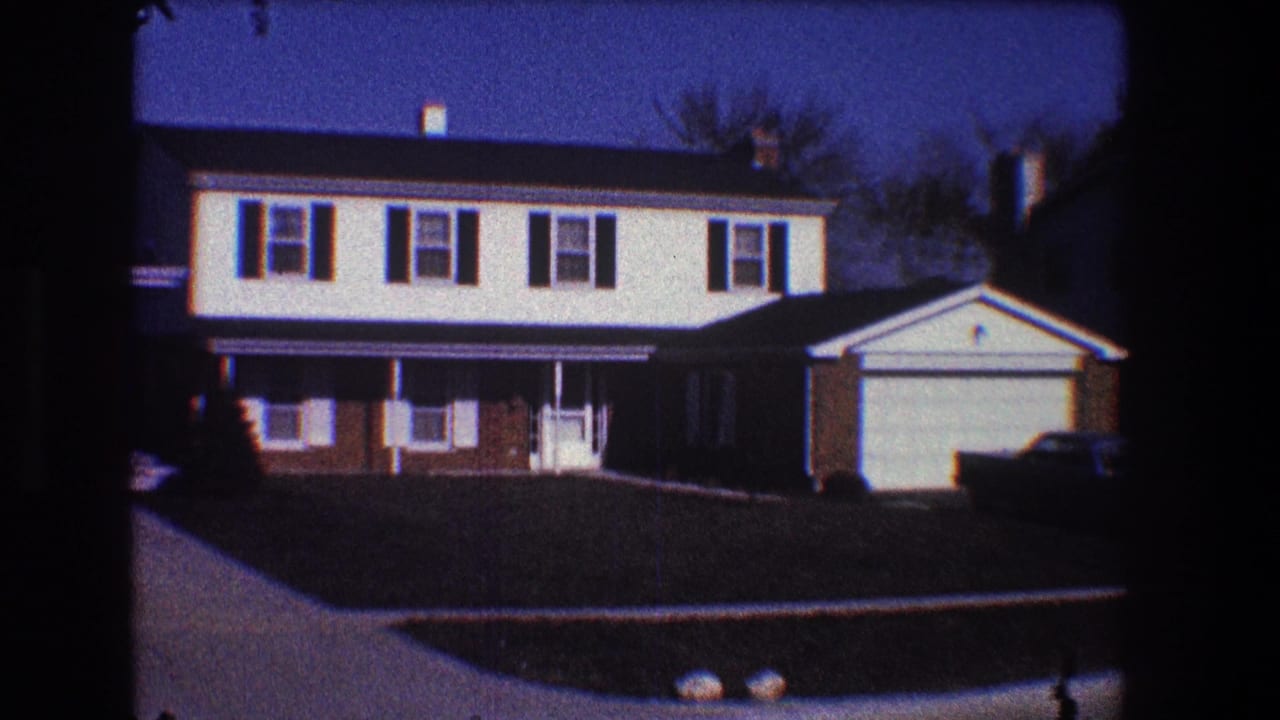 Suburban house facade with garage, shutters, lawn, and driveway.