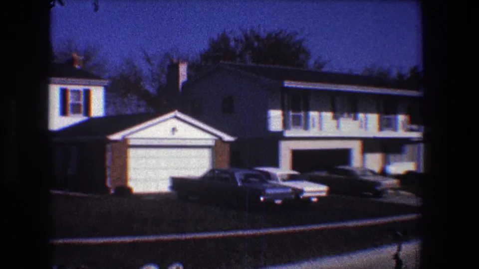 1968 Toledo suburban exterior with neighboring houses, attached garages, parked sedans, lawns, and leafless trees.