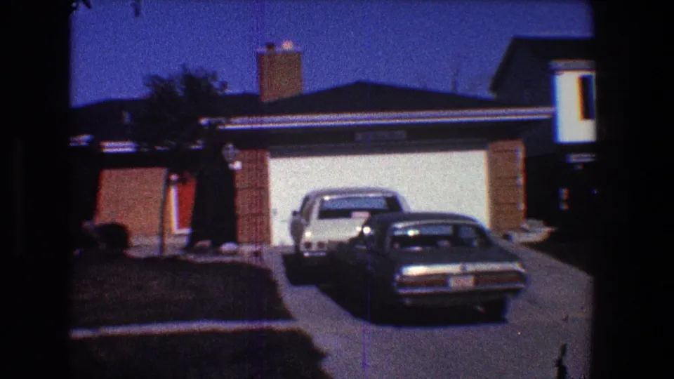 1968 Toledo suburban home exterior with brick accents, a garage, chimney, and two cars parked in the driveway.