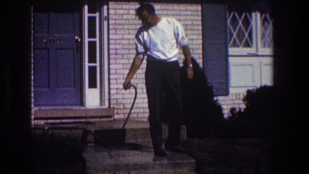 In 1968 Toledo home-movie footage, a man in a white shirt stands by the front steps of a brick house while cleaning with a hose.