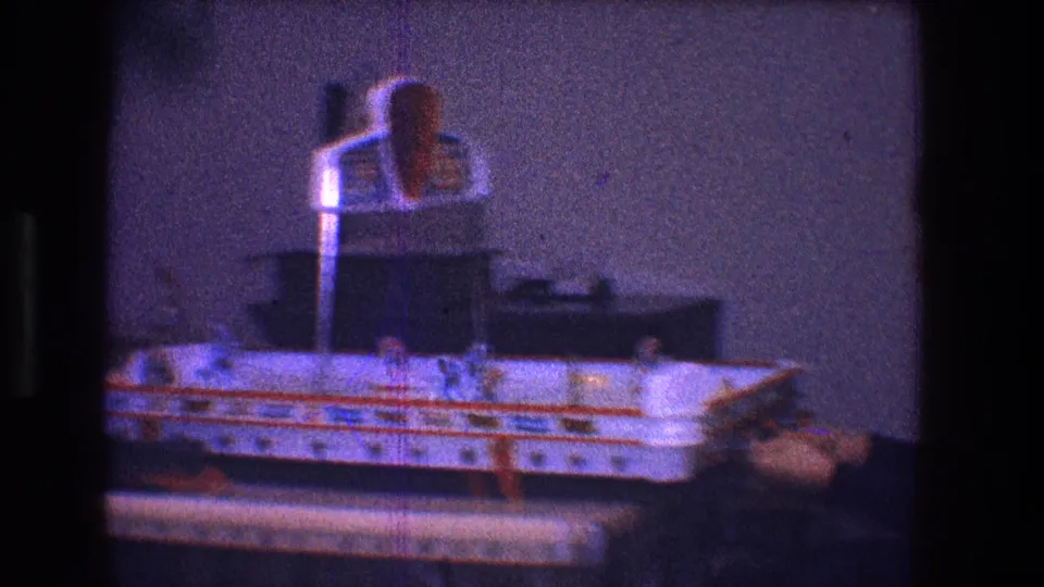 Soft 8mm frame from Toledo in 1968 showing the tabletop hockey game closer in, with player figures and a hand manipulating the play area.