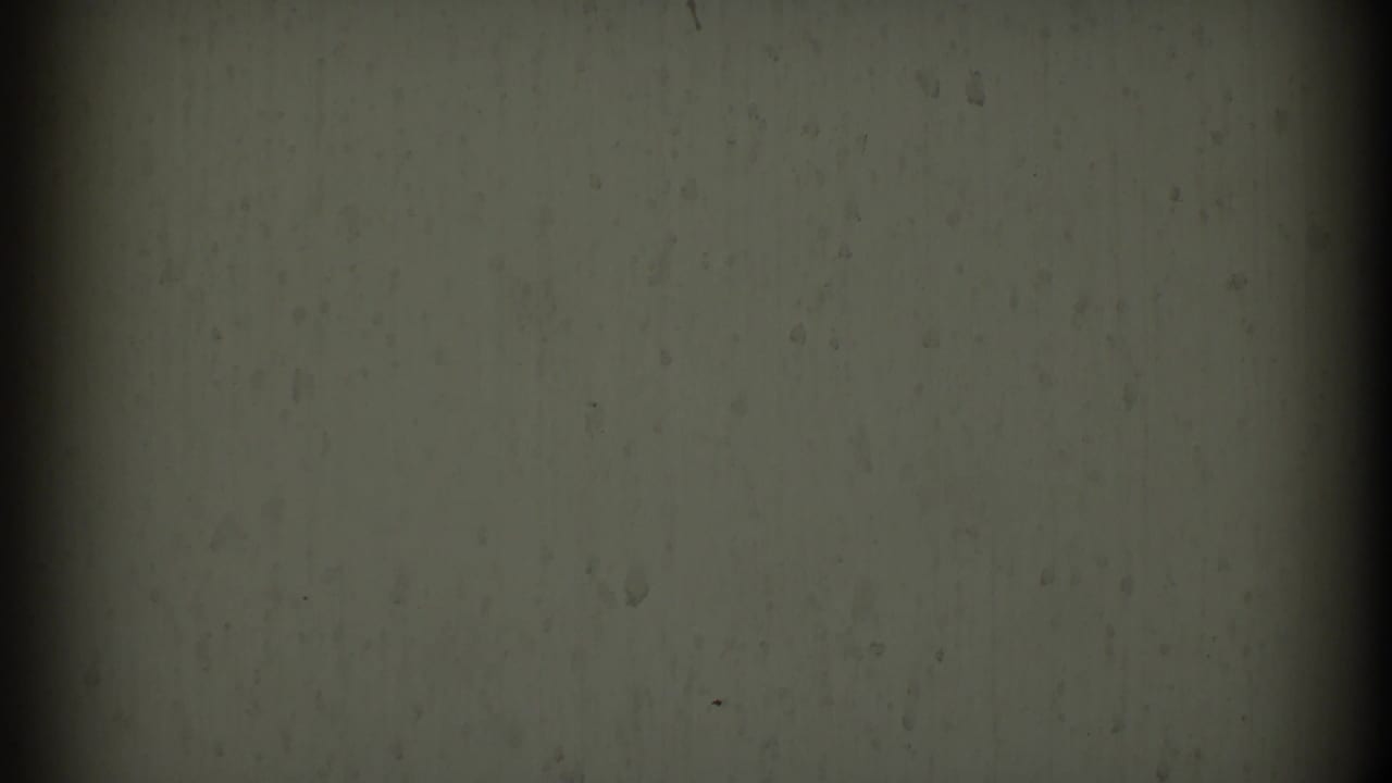 Plain gray film surface with dark vertical band near the left side.
