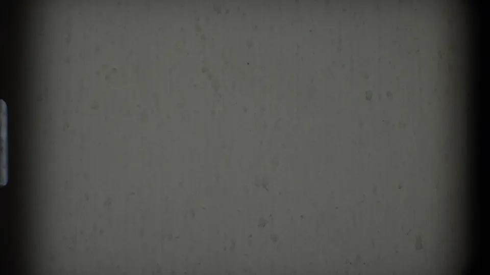 1968 Toledo-source 8mm frame showing gray leader, a small faded blue code-like mark, dust, and vertical edge shadow.