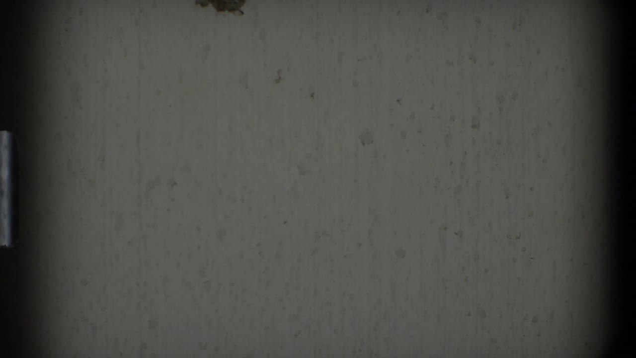 Dim wall surface with a narrow vertical highlight and heavy dark borders.