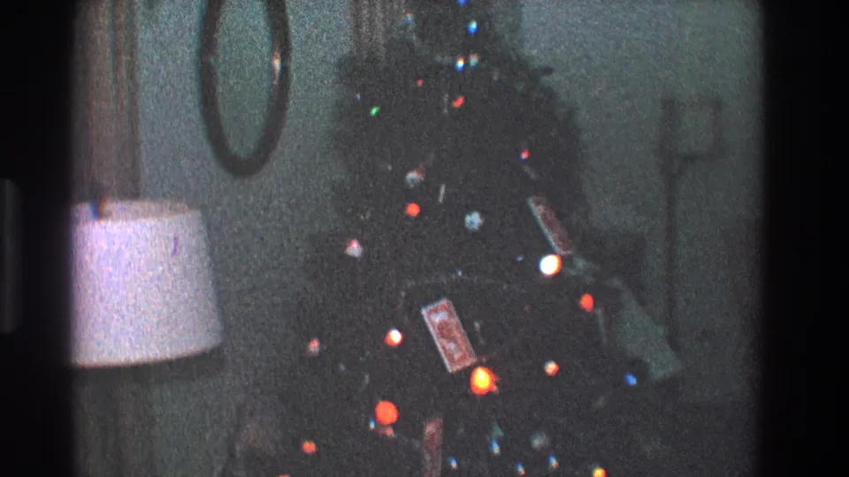 1968 Toledo interior frame with a soft, grainy view of a lit Christmas tree, ornaments, lamp, and circular mirror.