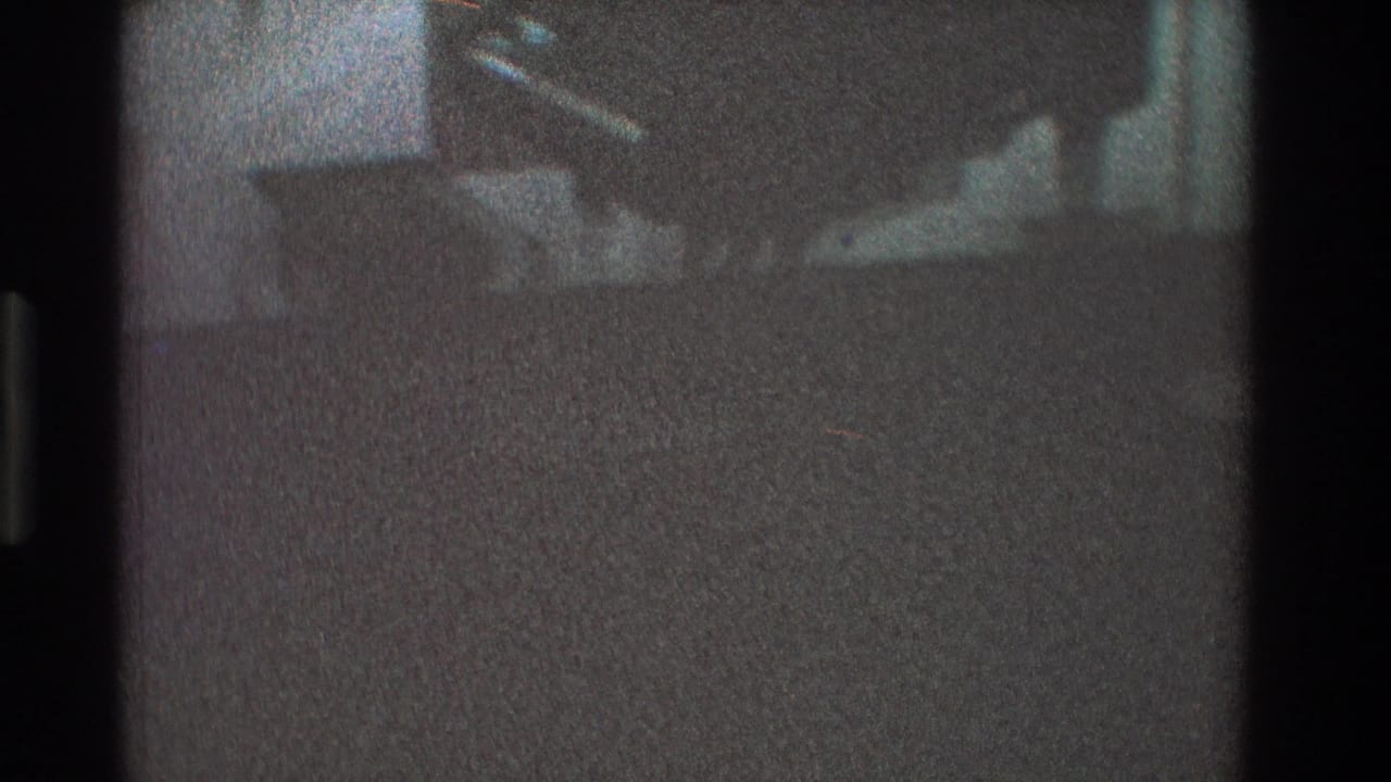 Dark carpeted living room area with a chair partly visible near the wall.