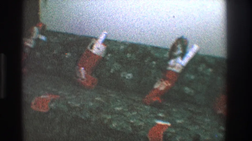 Toledo, Ohio 1968 holiday interior with red-and-white stockings hanging in a row above dark carpet.