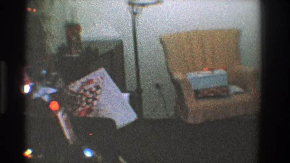 1968 Toledo holiday interior with a decorated Christmas tree, glowing lights, lamp, orange chair, and wrapped gift.