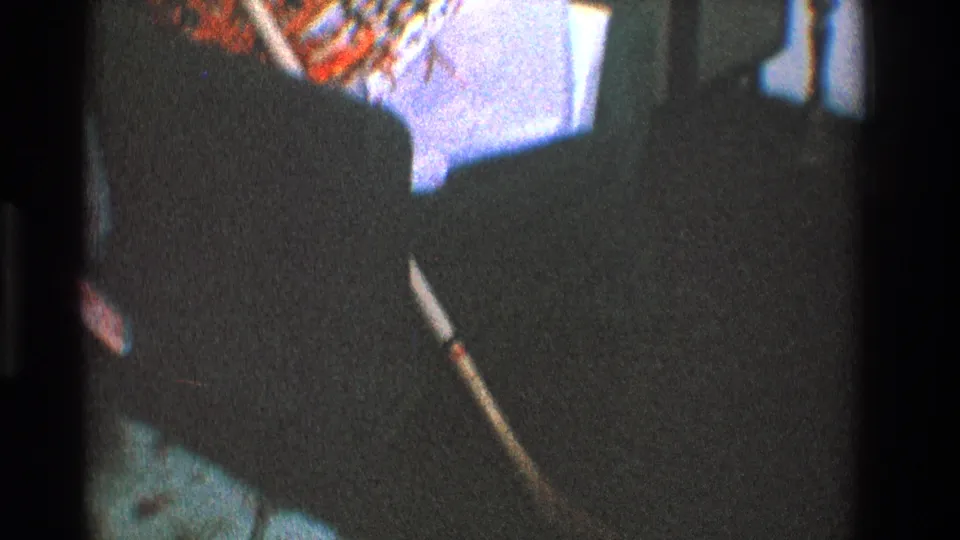 1968 Toledo frame with the chair partly cropped as the broom handle and patterned textiles remain visible over dark carpeting.