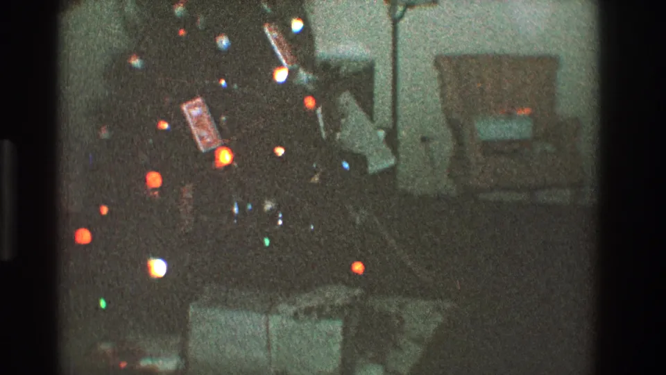 1968 Toledo home interior showing a lit Christmas tree, ornaments, gift boxes below, a wall mirror, and nearby living room furniture.