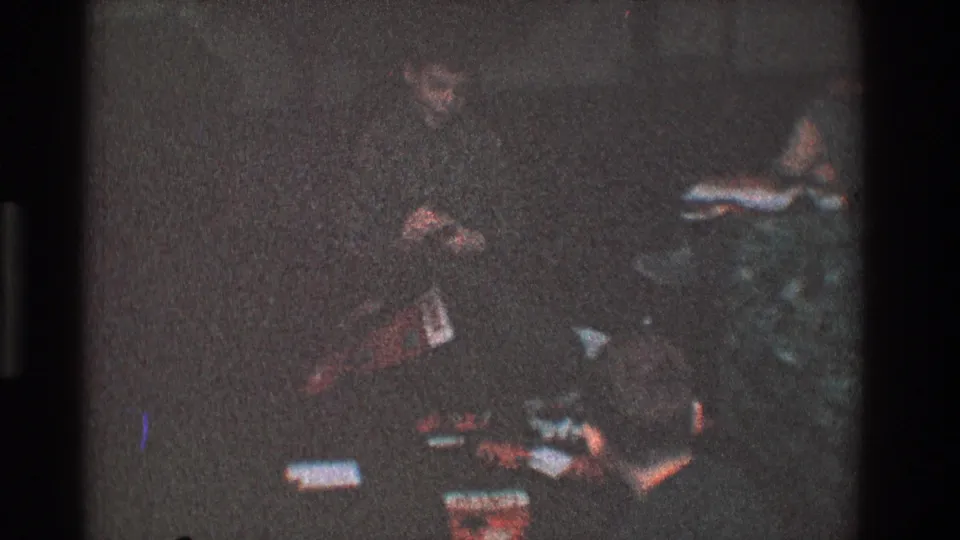 Late clip frame from the 1968 Toledo holiday interior, showing a darker area of the room with presents and furniture near the tree.