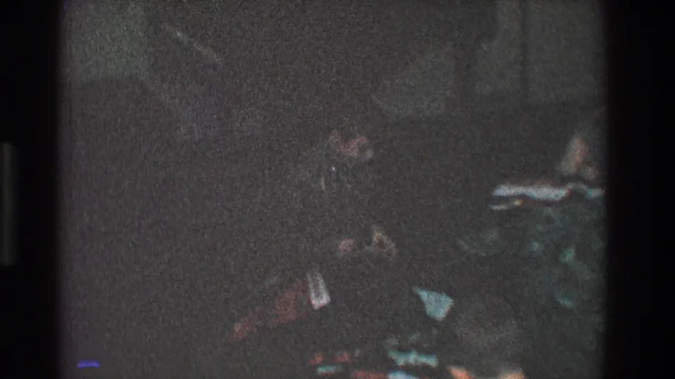 A final dark frame from the 1968 Toledo home movie shows the child low in frame beside scattered household items.