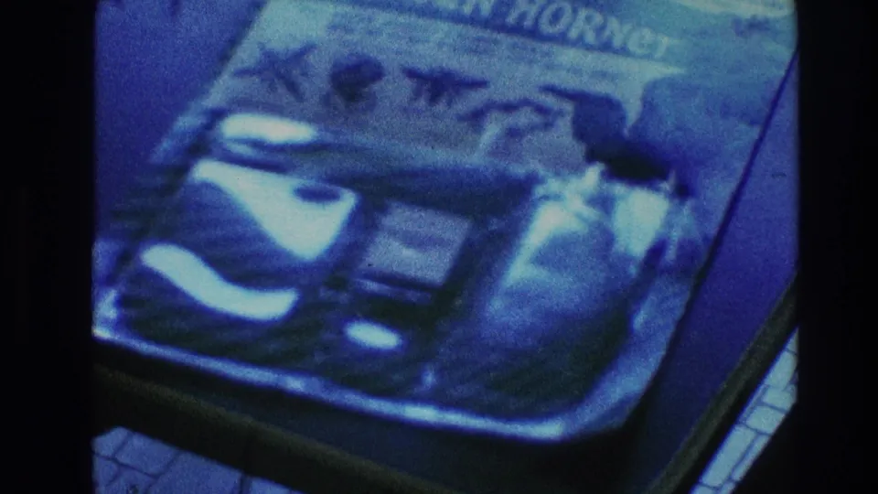Final 1968 Toledo close-up showing the Green Hornet comic cover across most of the frame in grainy blue-tinted 8mm footage.