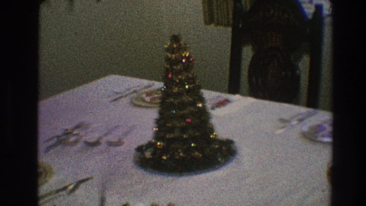 Miniature Christmas tree centerpiece on a formally set dining table.