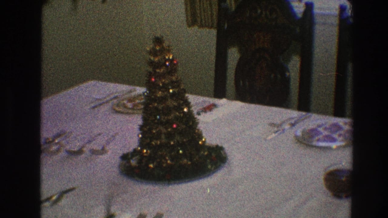 A 1968 Toledo dining-room view centers a tinsel-style miniature Christmas tree among plates and silverware on a white tablecloth.