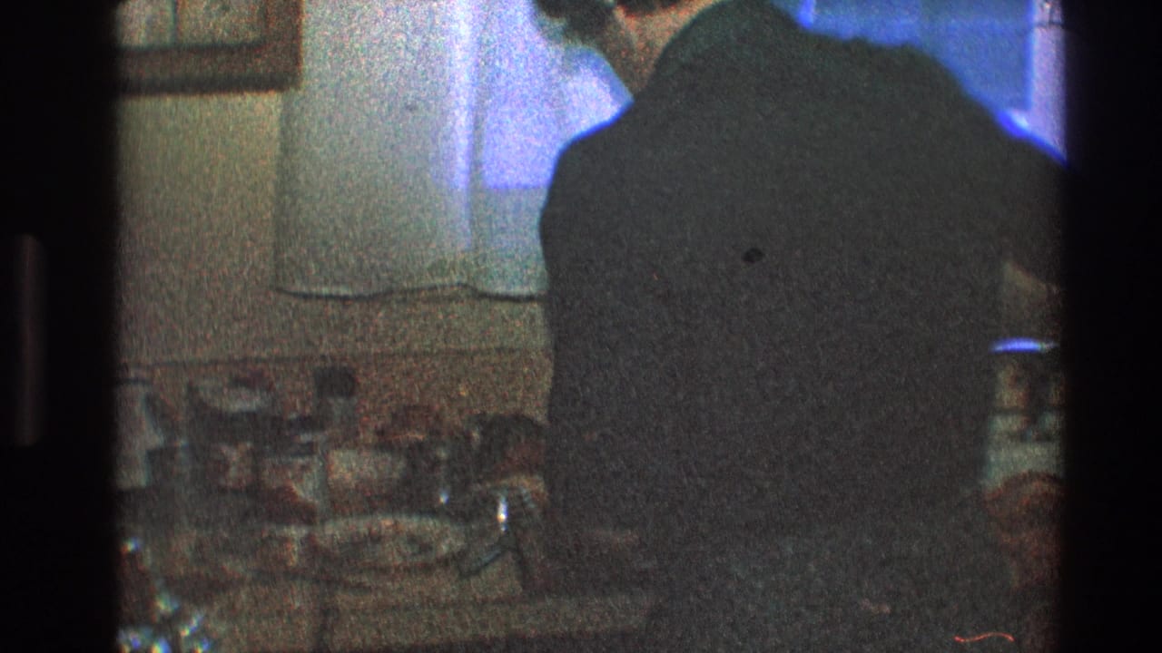 Man at the sink with dishes and kitchen items visible on the counter.