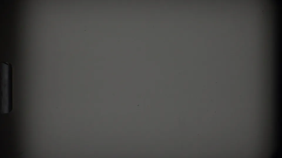 1968 Toledo 8mm frame showing a mostly blank gray panel, dark obstruction, and small handle-like protrusion in low light.