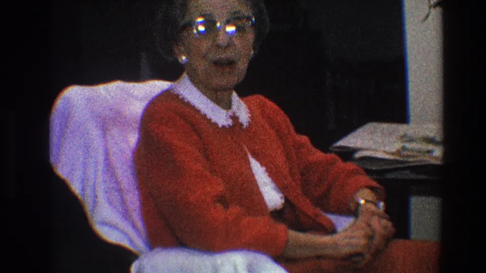 A Toledo 1968 frame shows the woman turning toward the camera, with glasses reflecting light and her hands resting together.