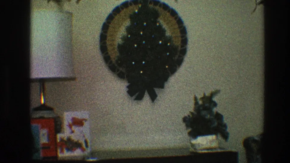 A Toledo home interior shows a Christmas wall wreath, lamp, holiday cards, and small plant on a console table.