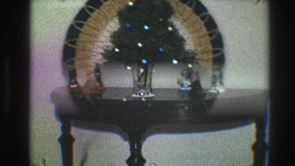 1968 Toledo interior frame showing a console table, vase, figurines, and lit wreath decor in soft 8mm focus.
