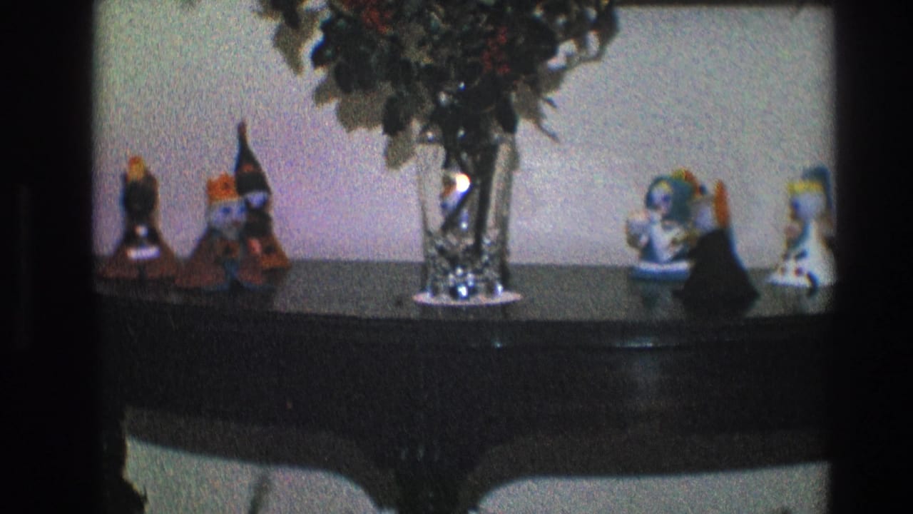 1968 Toledo interior detail with a central glass vase and small decorative figurines arranged on a dark console table.