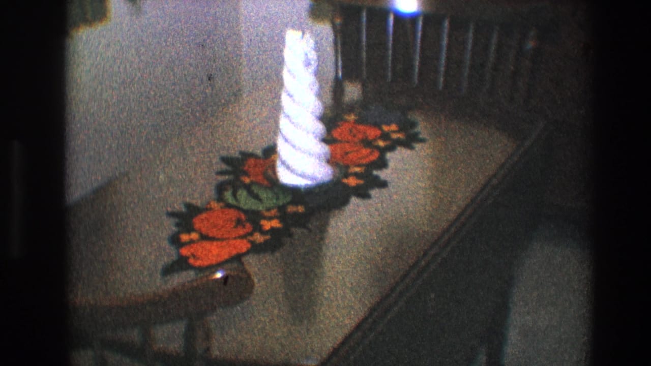 Wooden table with a white spiral candle on a colorful crocheted floral runner.