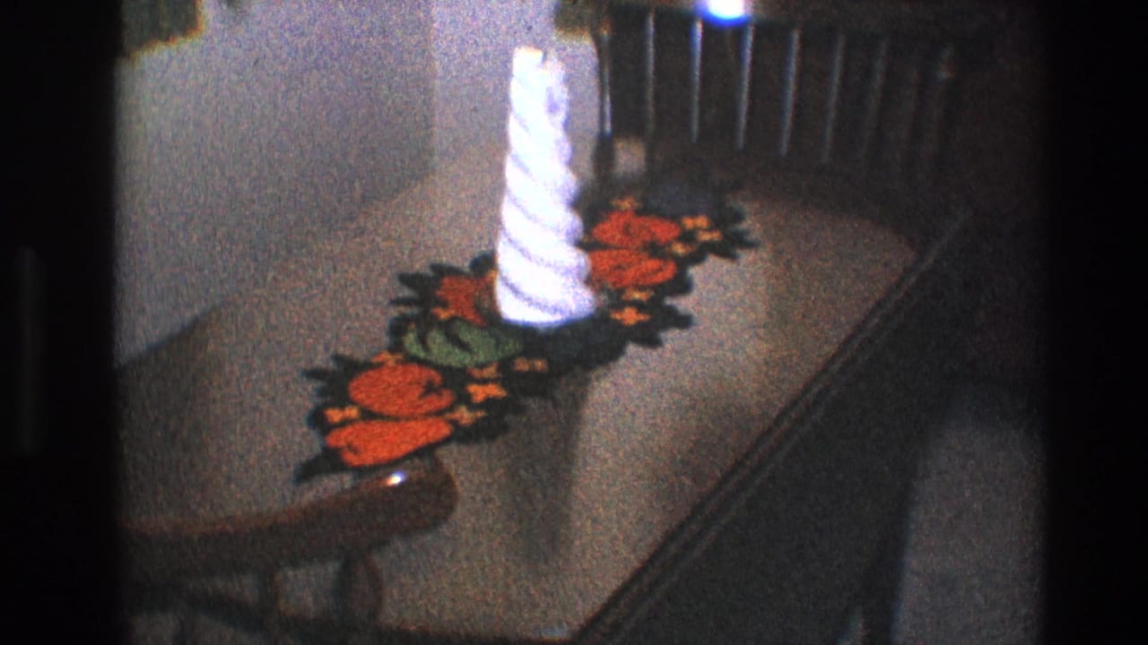 White candle and floral crochet runner on a wooden table near a chair back.
